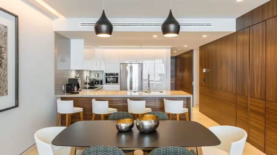 Enclosed stacked laundry is next to fridge & built-in wood wall storage