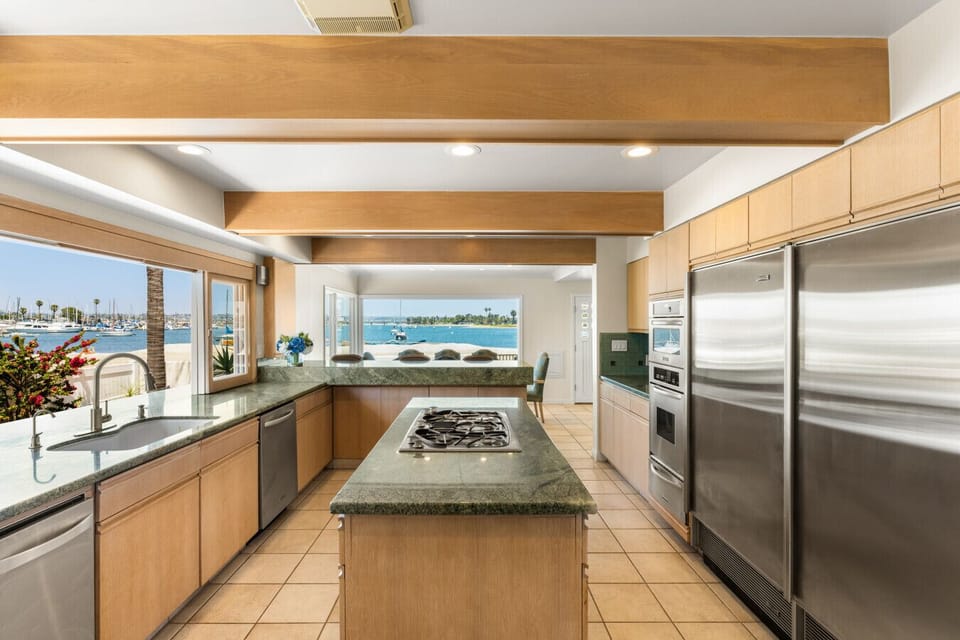 Chef`s kitchen with premium appliances, a large island, and stunning bay views.