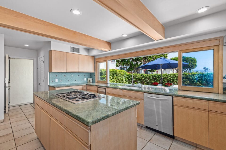 Sunlit interiors, generous counter space, and picturesque bay views create the perfect gathering spot.