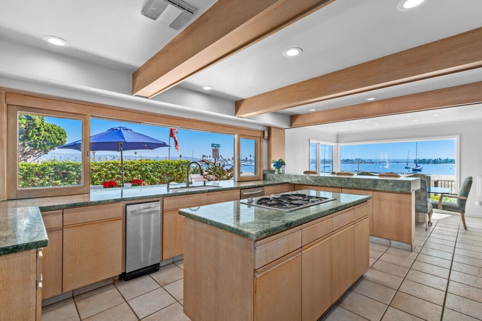 A spacious gourmet kitchen featuring expansive windows that bring the bay right into the home.