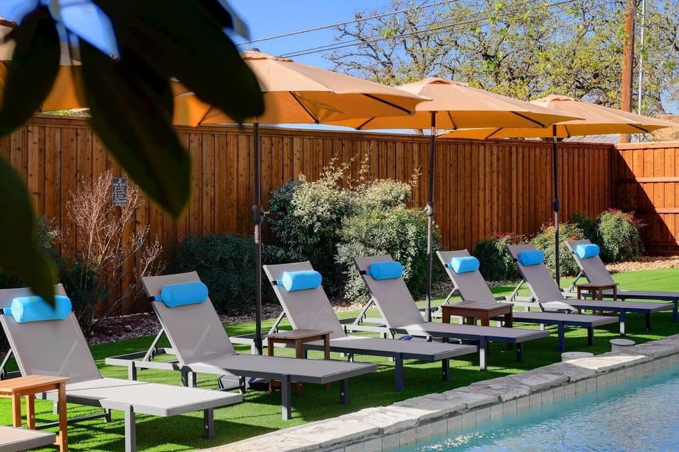 Lounge chairs with headrest and adjustable umbrellas  compliment the resort style backyard at the Vibewell Haus. . 