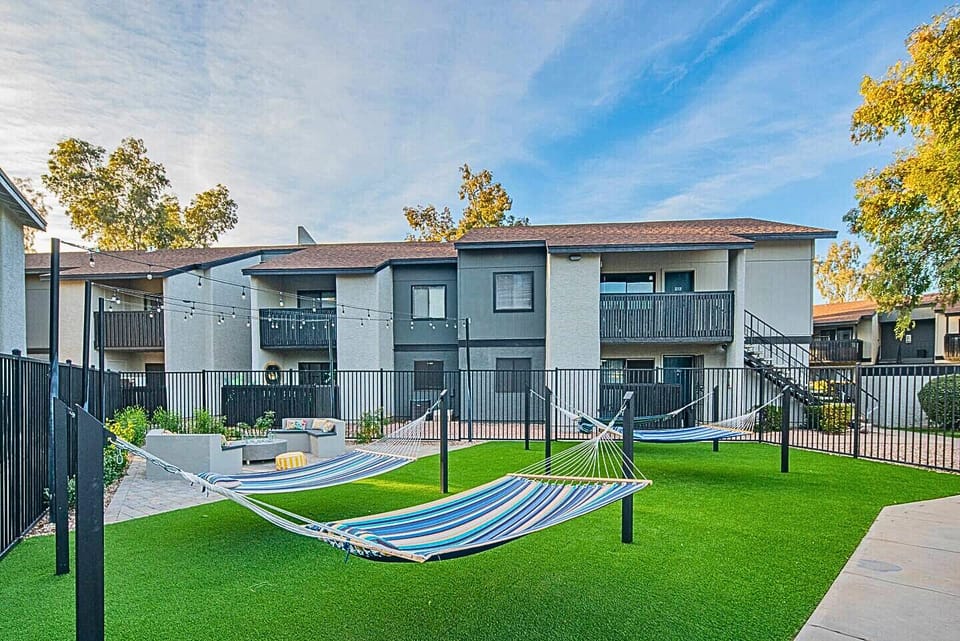 Spacious courtyard featuring colorful hammocks and string lighting.