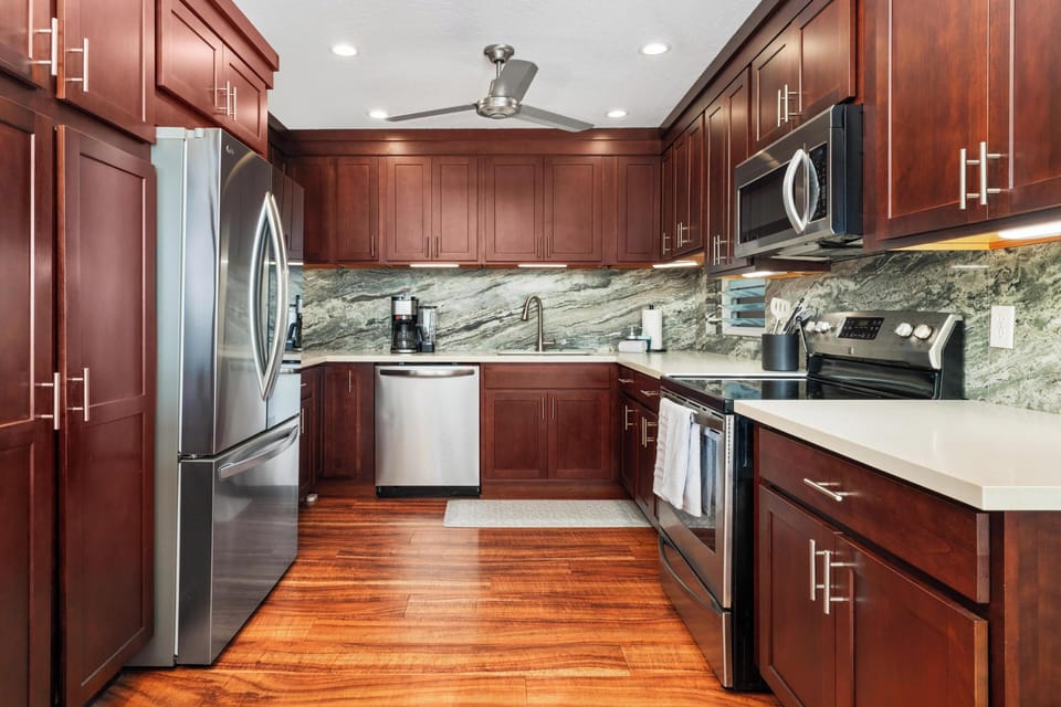 Cook your favorite meals in this fully-equipped kitchen with granite counters, stainless appliances, and rich cherry cabinetry.