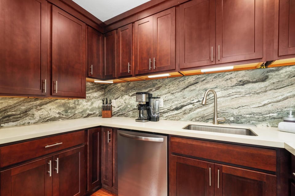 Step into your gourmet kitchen, where rich cherry cabinets and stunning marble backsplash create an elegant cooking space. Everything you need is here, from stainless steel appliances to under-cabinet lighting that sets the perfect mood.