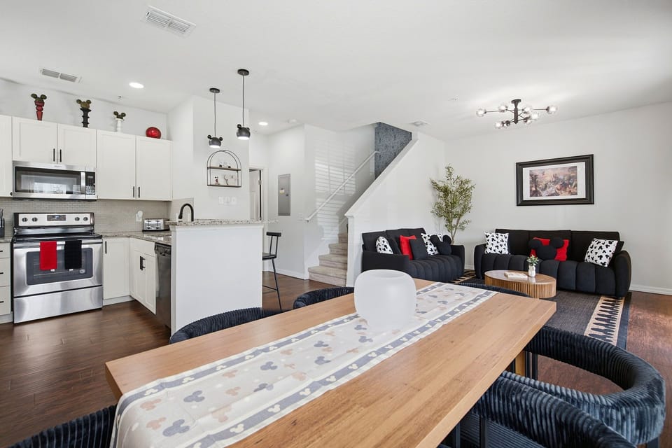 Bright open-concept living with modern kitchen, dining table, and cozy lounge