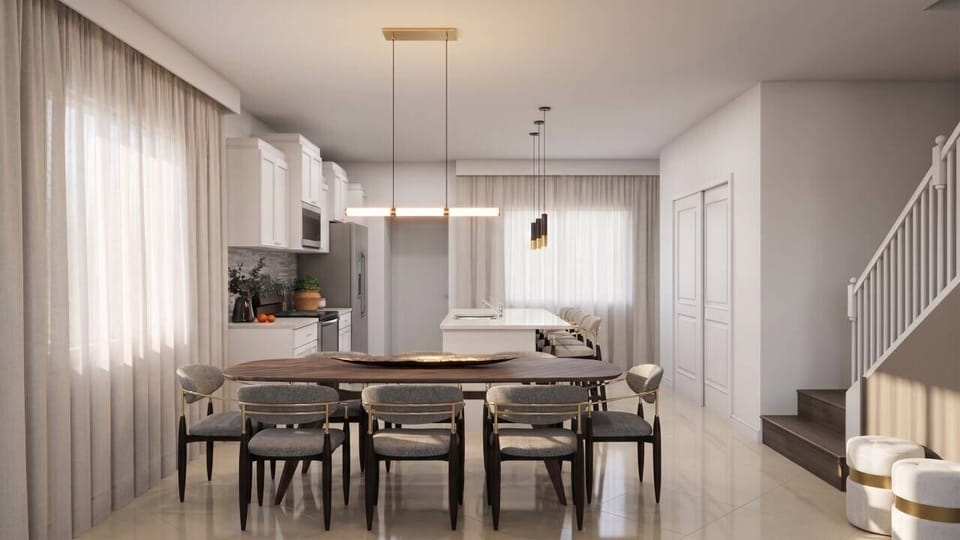 This bright, airy kitchen boasts sleek cabinetry and a spacious island ideal for gatherings. The elegant dining table with cozy chairs invites shared meals, while large windows fill the space with natural light.