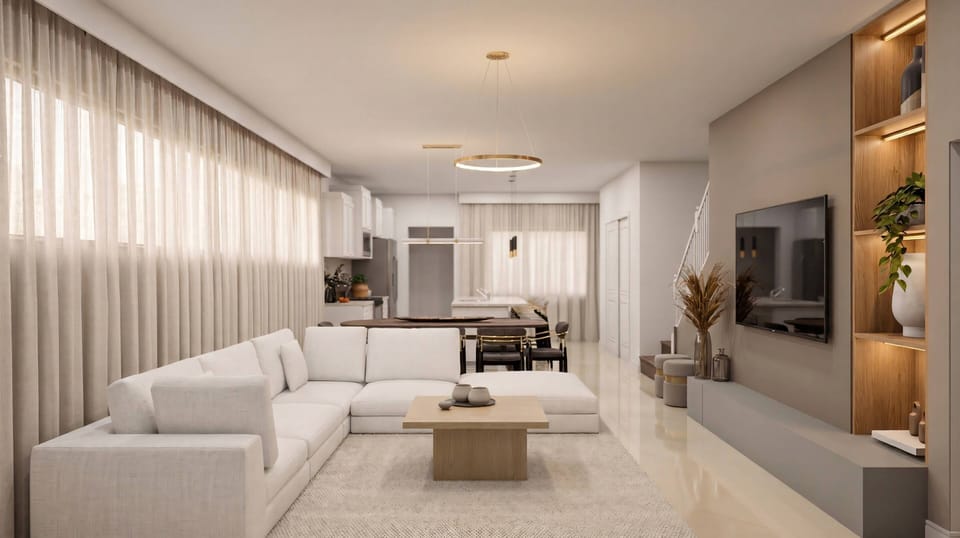 This bright and airy living room invites relaxation with its plush white sectional and natural wood coffee table, while soft light through sheer curtains adds warmth to the contemporary decor.