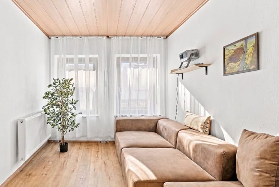 Lichtdurchflutetes Wohnzimmer mit Sofa & großen Fenstern – entspannen in Trier