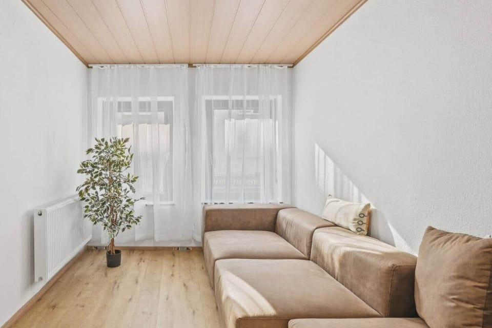 Lichtdurchflutetes Wohnzimmer mit Sofa & großen Fenstern – entspannen in Trier
