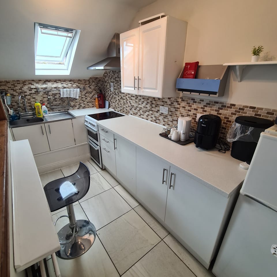Bright kitchen with breakfast bar, full appliances, and stylish backsplash