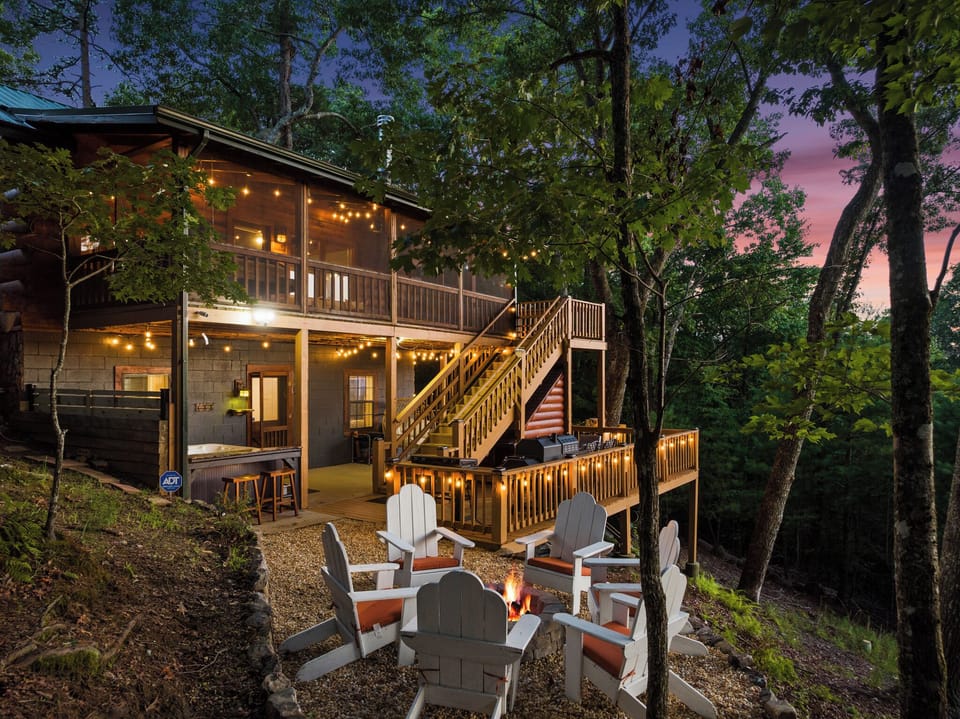 Twilight cabin retreat with hot tub, fire pit, and glowing forest deck