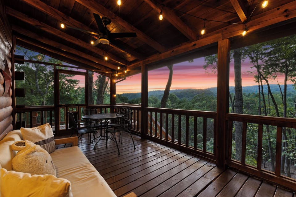 Covered mountain-view deck with cozy seating and stunning sunset views