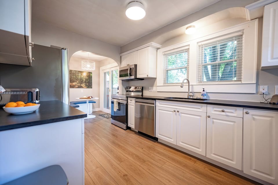 Bright modern kitchen with stainless appliances and sunny dining nook