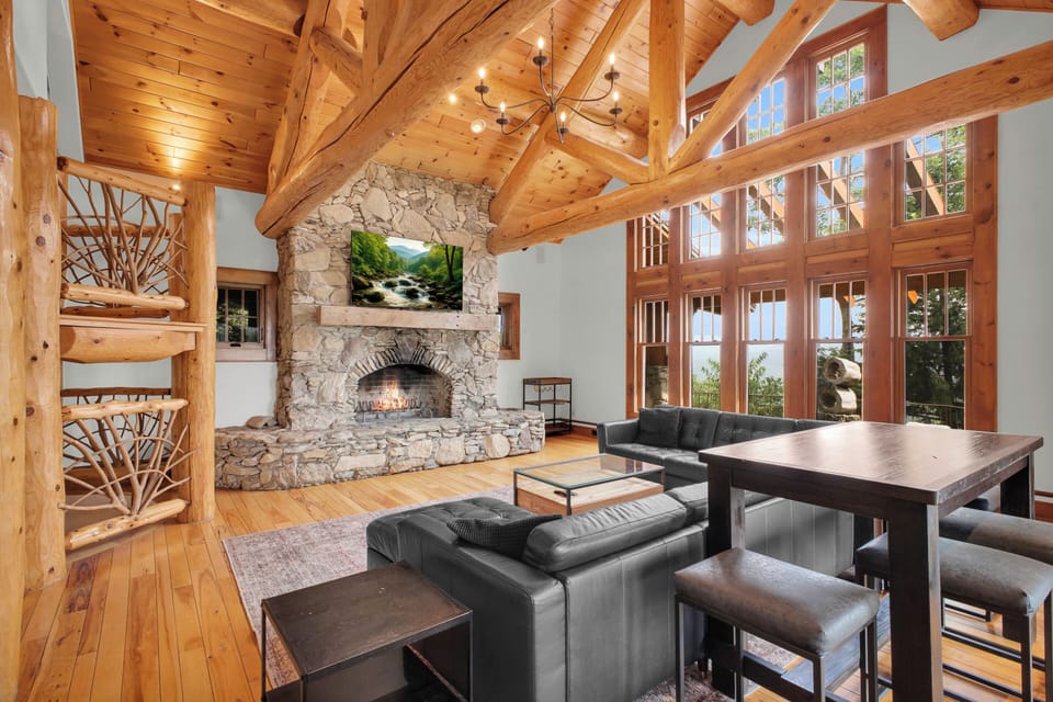 Curl up on the leather sectional in front of the stone fireplace, two stories of log trusses and picture windows rising overhead.