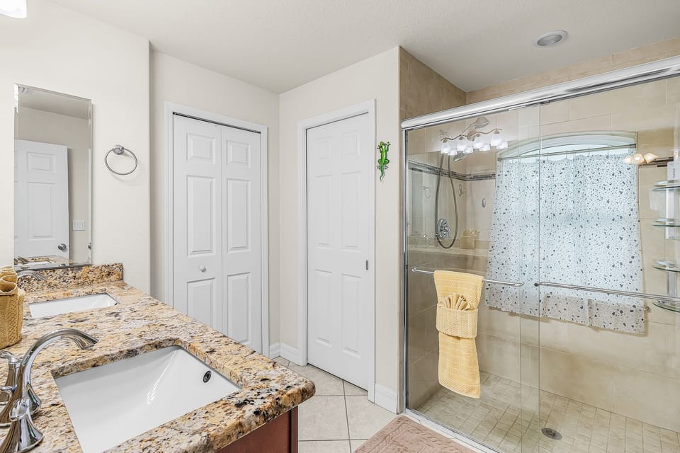 The attached primary bathroom offers a double-sink vanity & walk-in shower