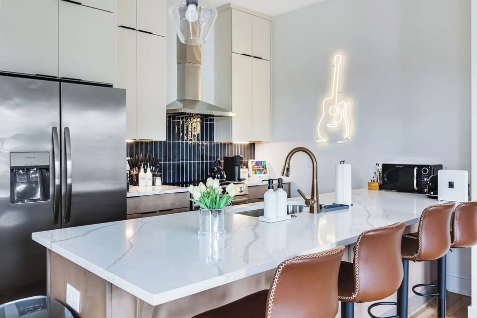The fully equipped kitchen features a spacious island with bar seating, making it easy to prepare meals, gather for coffee, or enjoy a quick bite before heading out.