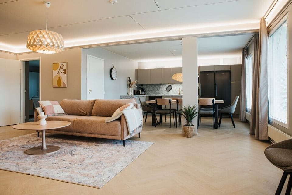 An open-plan living and dining space filled with natural light from large windows.