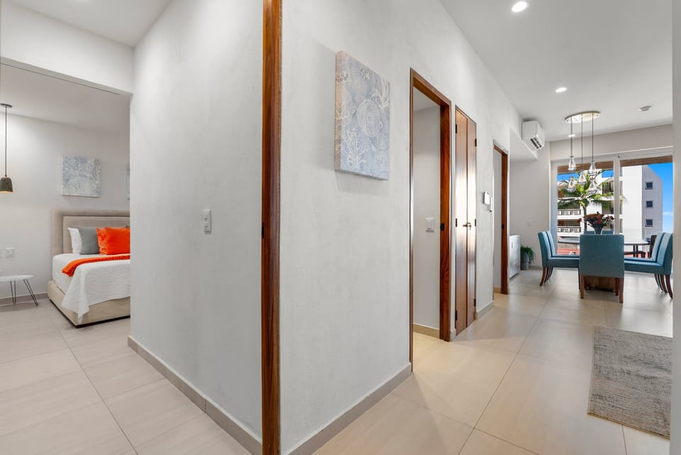 Explore the bright open design connecting the main living area to the secondary bedroom. Framed by beautiful wood entryways, this space perfectly flows into the dining room.