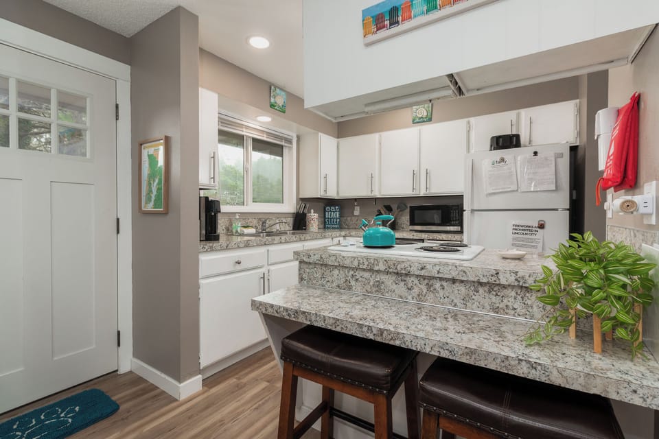 Your well-equipped kitchen invites you to savor leisurely mornings at the breakfast bar, while crisp white cabinetry and granite countertops provide ample space to prep memorable meals together.