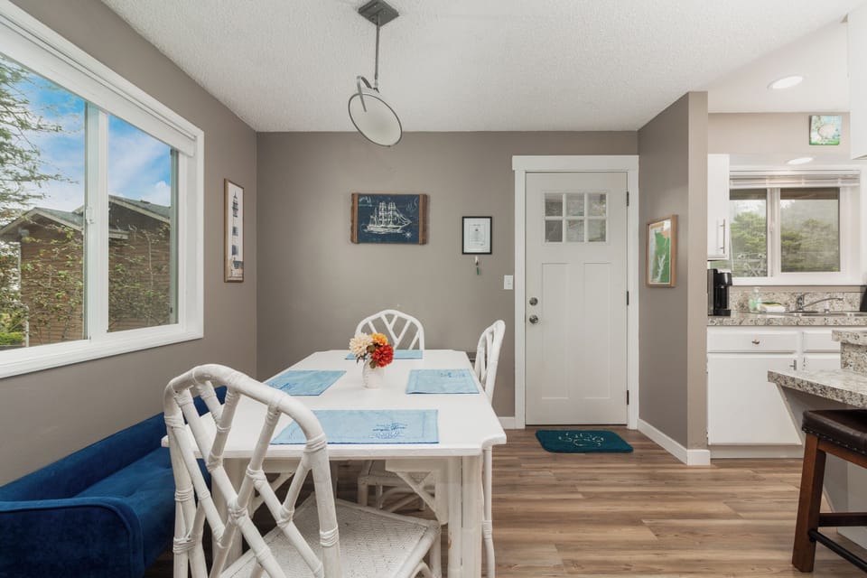 Gather around this bright dining space where sunlight spills through generous windows and every meal feels like a moment to remember.