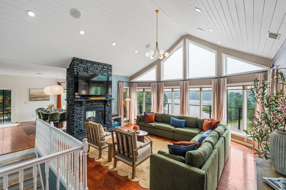 Bright vaulted great room with panoramic windows and a stunning stone fireplace