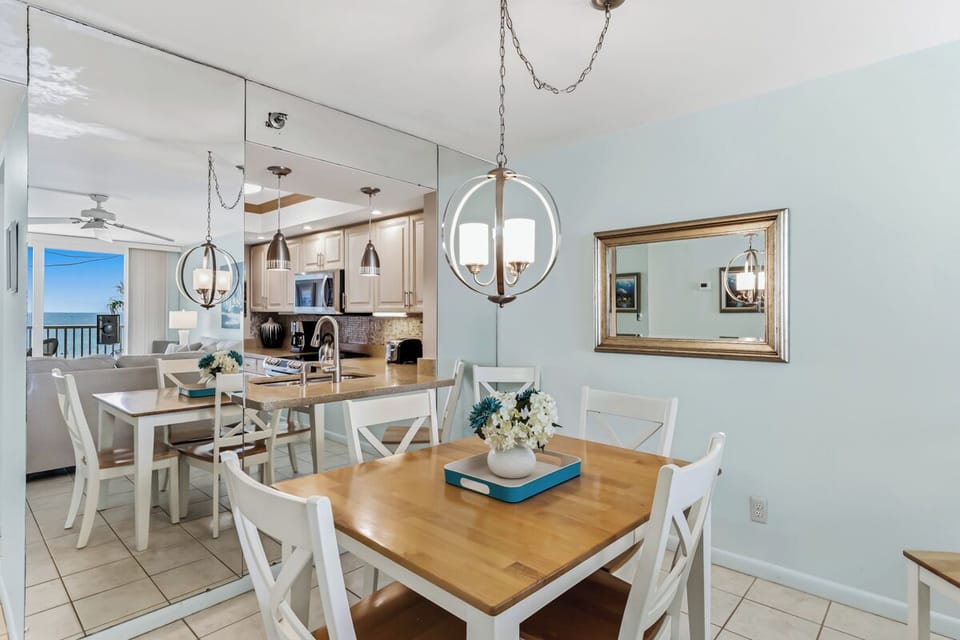 Gather around this inviting dining space where your meals are framed by coastal charm and open sightlines to the kitchen and ocean beyond. Bright, breezy, and perfect for your morning coffee or evening feast.