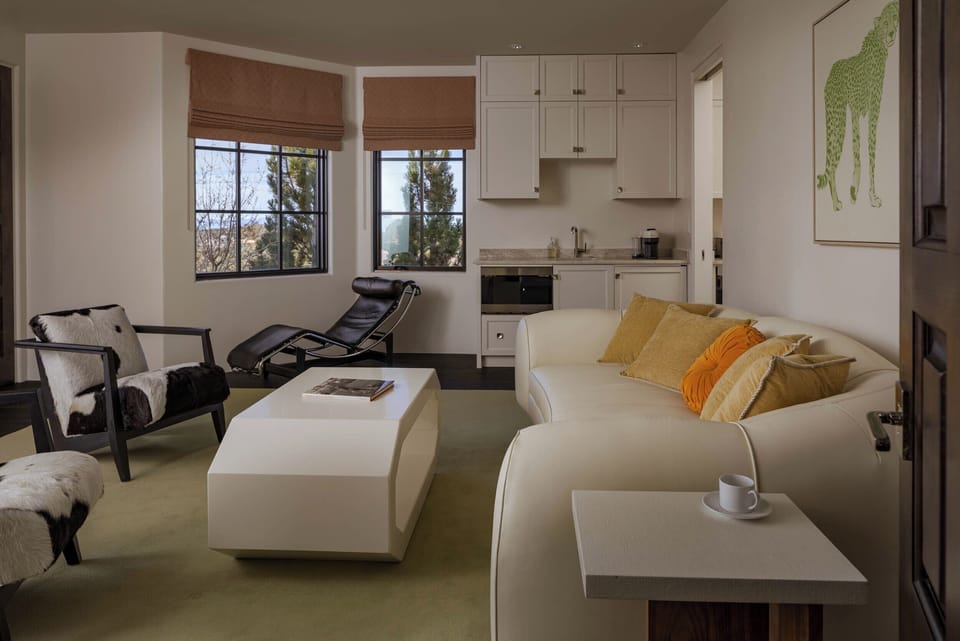Unwind in your open-concept studio with modern kitchenette, cozy seating, and golden accents creating a warm, sophisticated retreat.