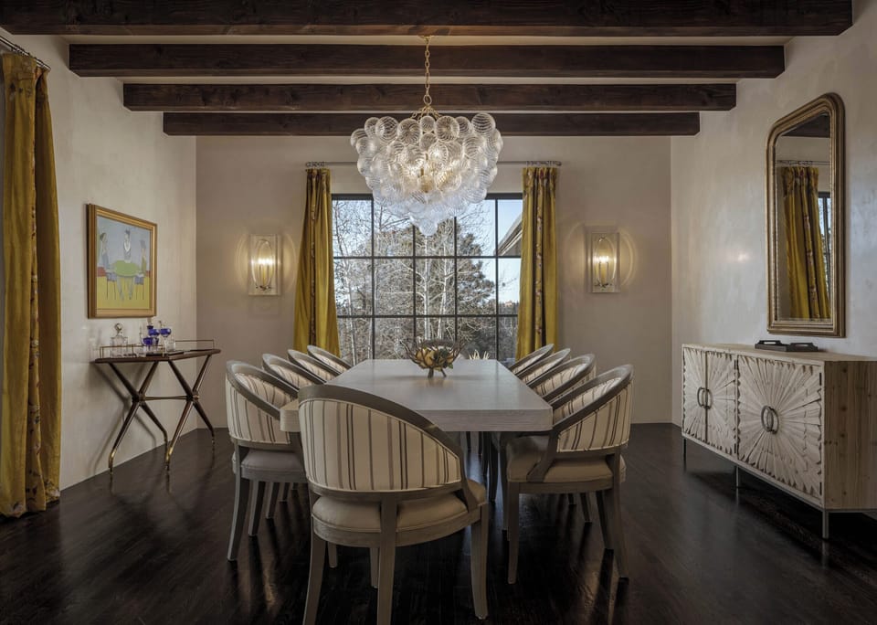 Gather around your elegant dining table beneath rustic beams and sparkling chandelier for memorable meals with loved ones.