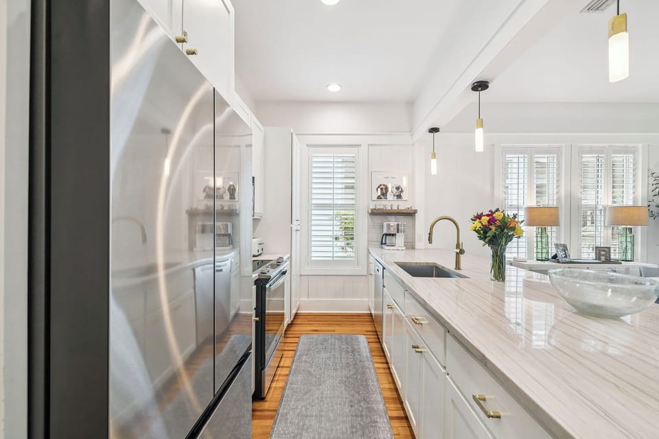 Your gourmet kitchen features gleaming marble counters, gold fixtures, and fresh flowers - perfect for cooking memorable meals during your stay.