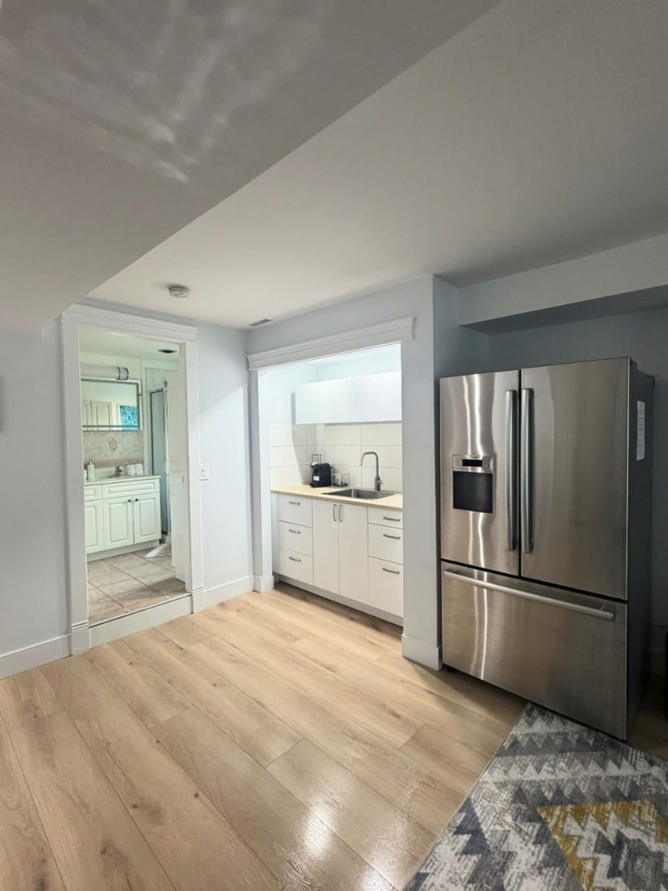 Bright modern kitchen with stainless steel fridge and clean finishes