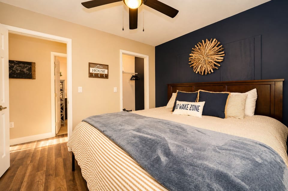 Cozy bedroom with navy accent wall, plush bedding, and warm modern style