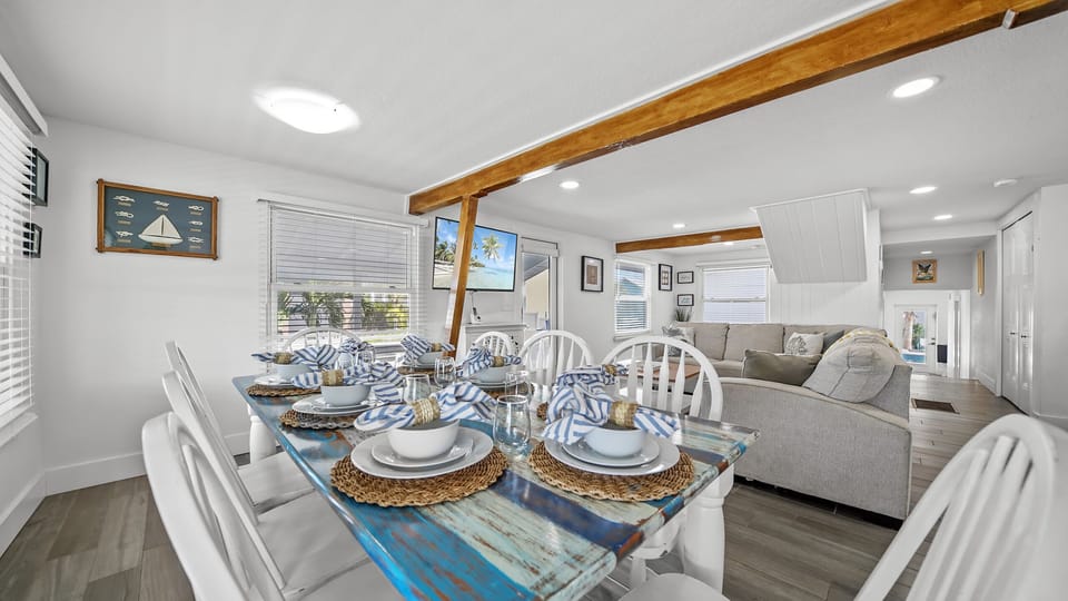 Bright coastal living space with rustic dining table and comfy seating