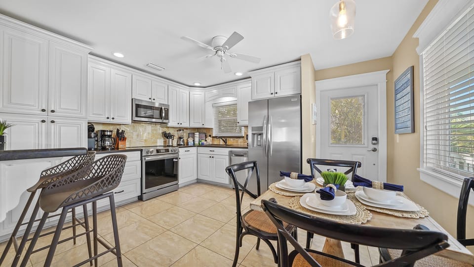 Bright kitchen with stainless appliances, breakfast bar, and cozy dining area