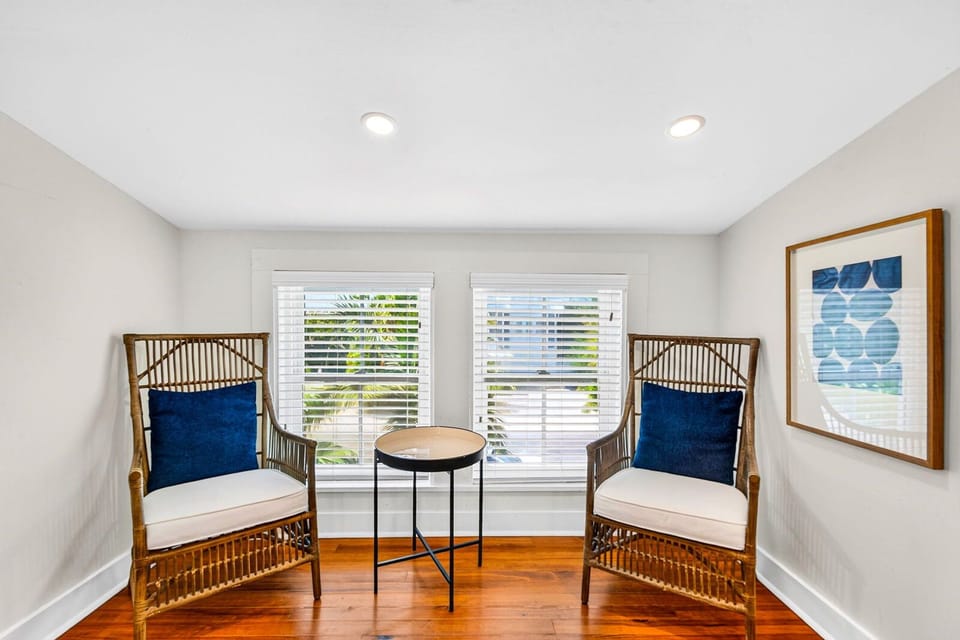 Bright window-side seating nook with wicker chairs and coastal style