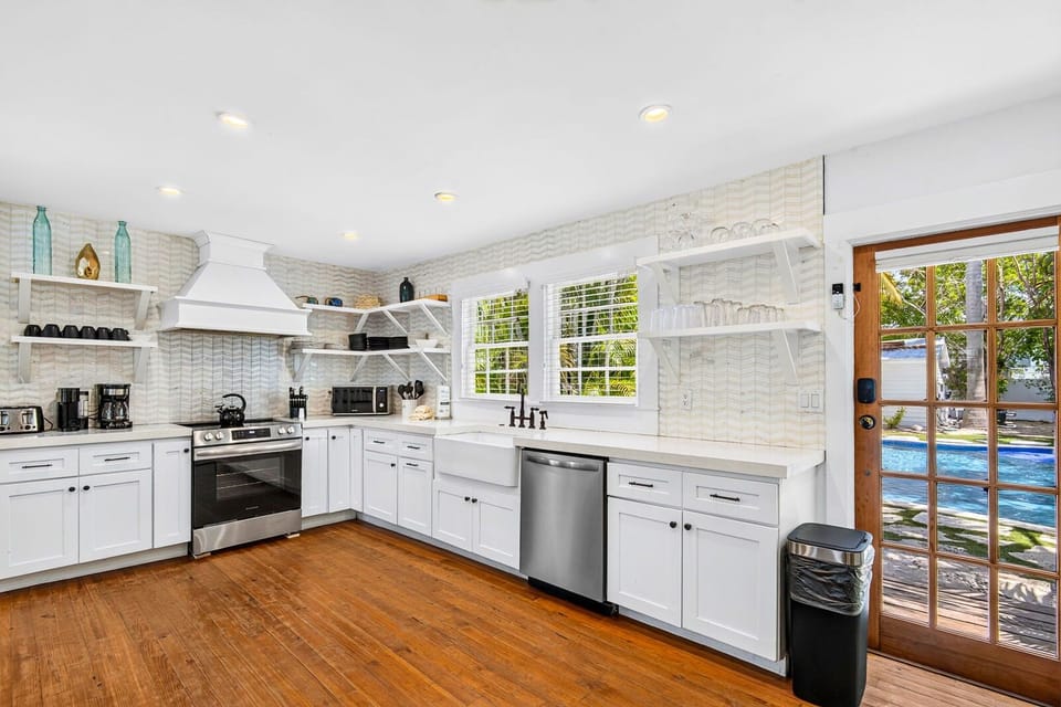 Bright farmhouse kitchen with pool views and airy open shelving
