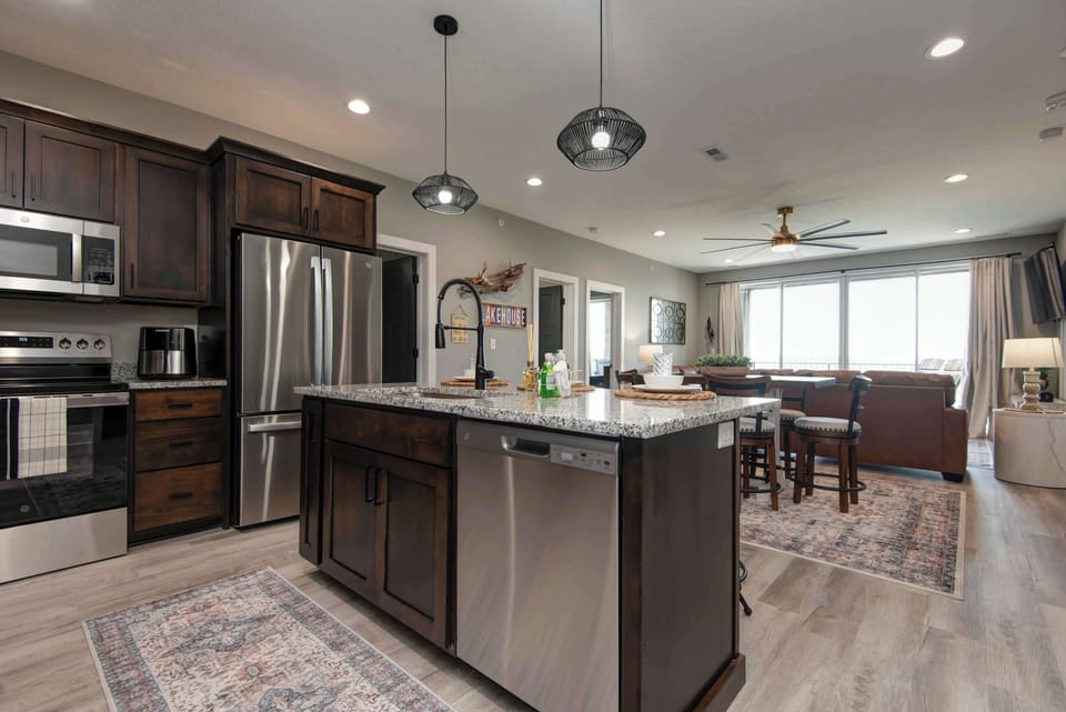 Bright and large kitchen featuring sleek stainless steel appliances, perfect for preparing family meals.
