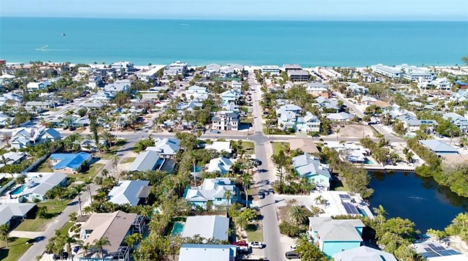 Aerial view of a charming beach neighborhood just steps from turquoise water