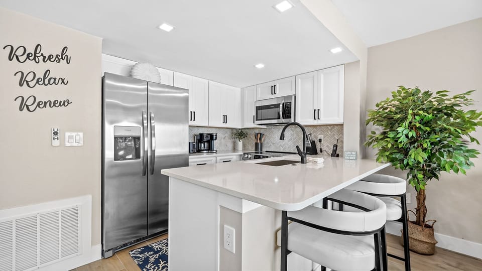 Bright modern kitchen with island seating and stainless steel appliances