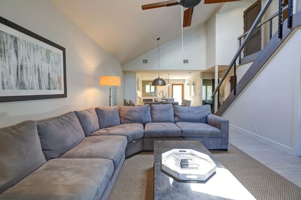 The spacious living room has a large sectional sofa, vaulted ceiling, and an open view toward the kitchen.