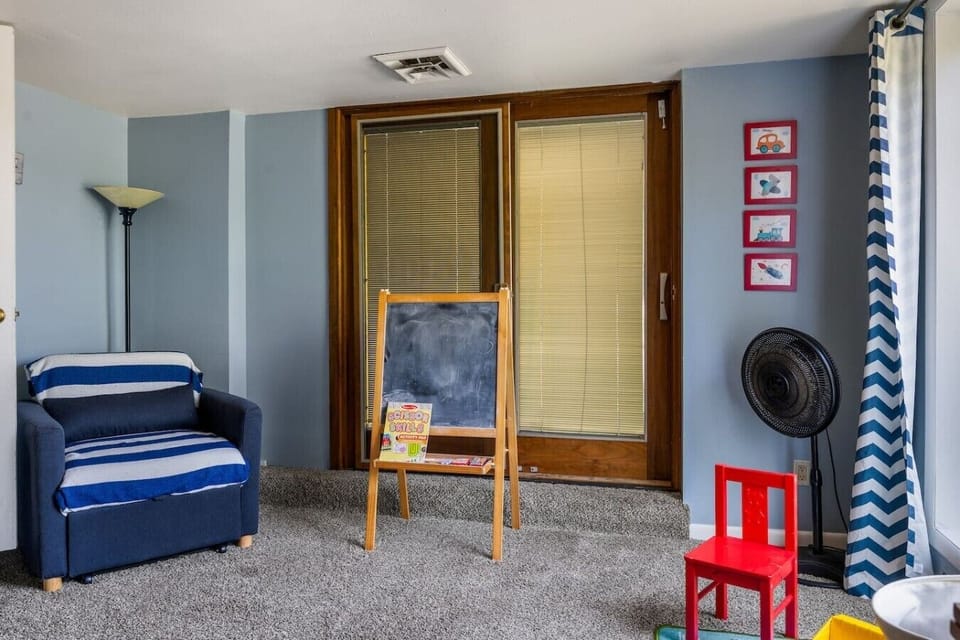 Bright play area featuring toys, books, a children`s table, and comfortable seating—perfect for keeping little ones entertained during your stay.