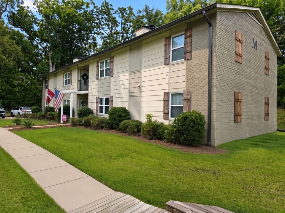 Charming exterior with manicured lawn, mature trees, and classic curb appeal