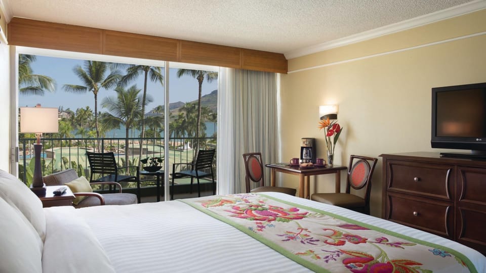 Tropical king room with private lanai, pool views, and ocean beyond