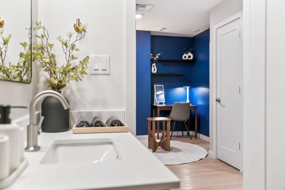 Modern bath vanity with a stylish workspace and bold blue accent wall