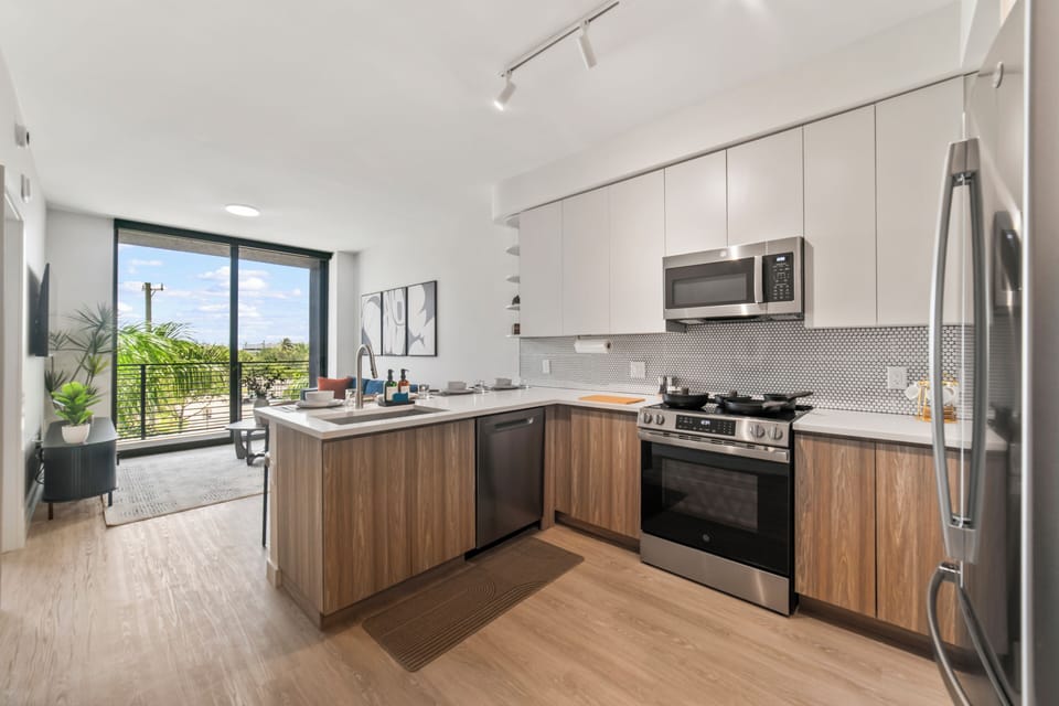 Bright modern kitchen with balcony views and sleek stainless appliances