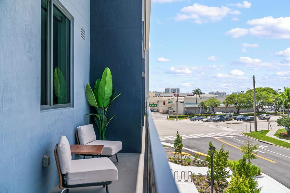 Cozy private balcony with seating and sunny city views
