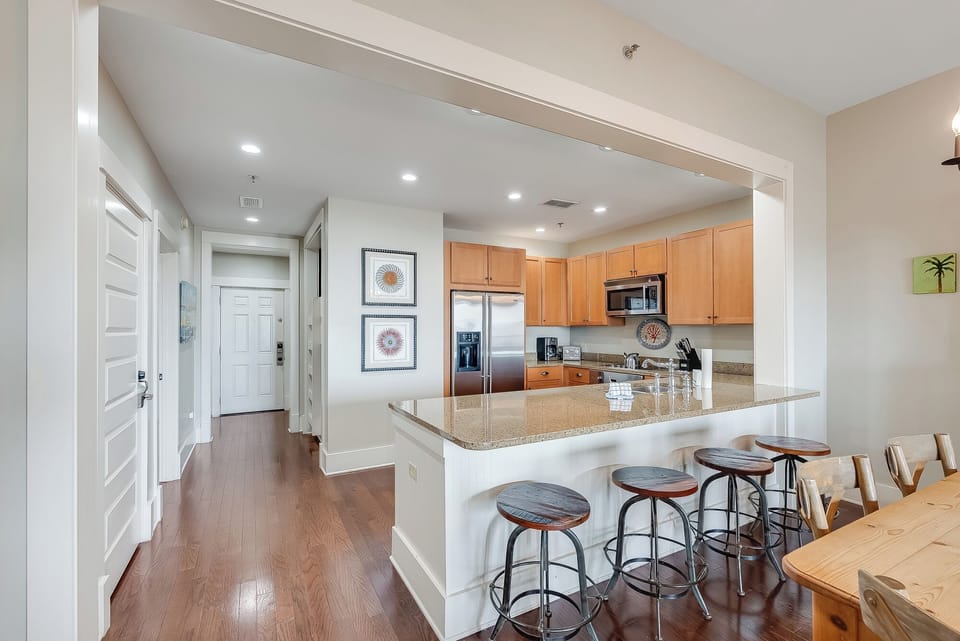 Bright open kitchen with granite bar seating and stainless appliances