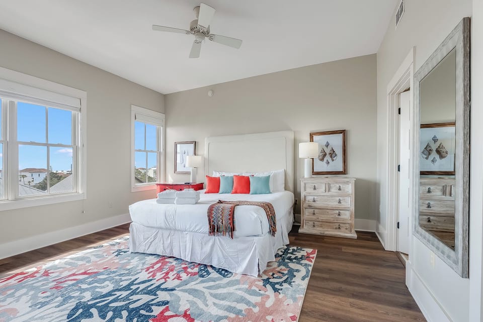 Bright coastal-style bedroom with large windows and inviting decor
