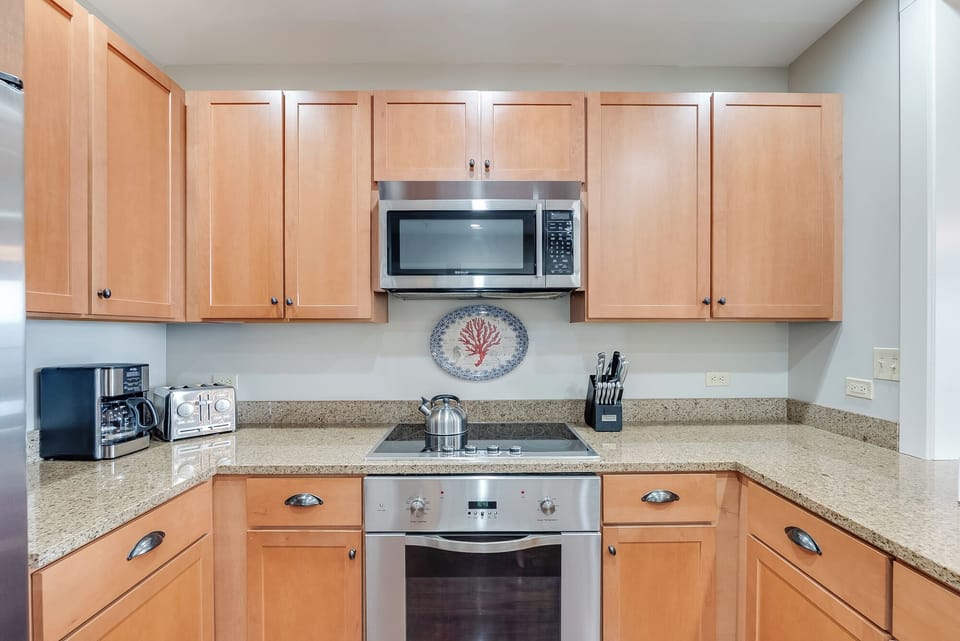 Bright kitchen with granite counters and stainless steel appliances