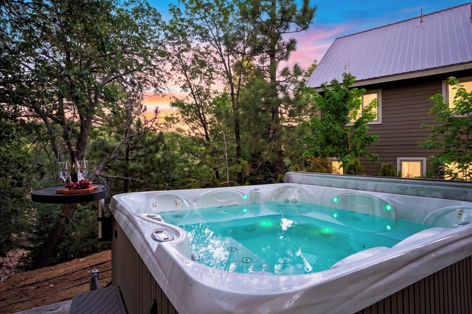 Outdoor hot tub on the wooden deck surrounded by trees.