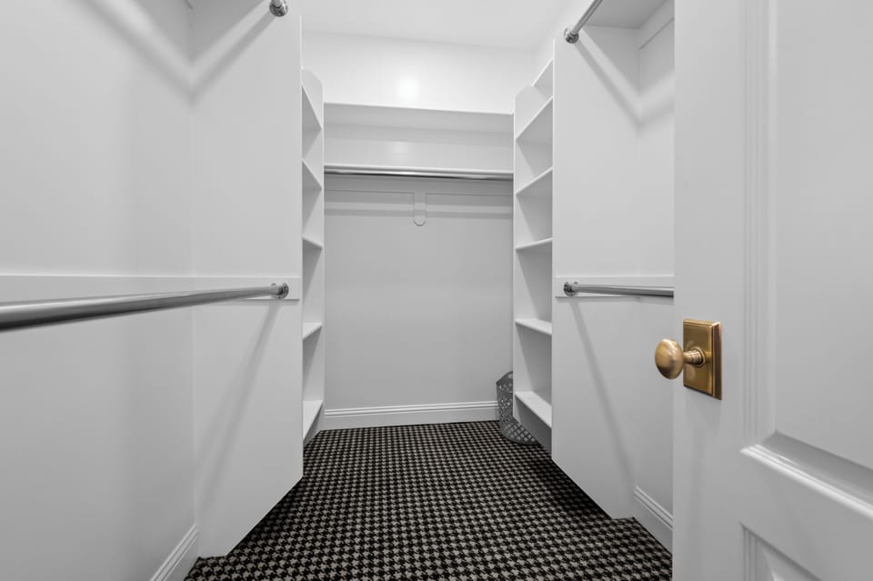 A spacious walk-in closet with built-in shelving and abundant hanging space provides convenient storage for longer stays and effortless organization.